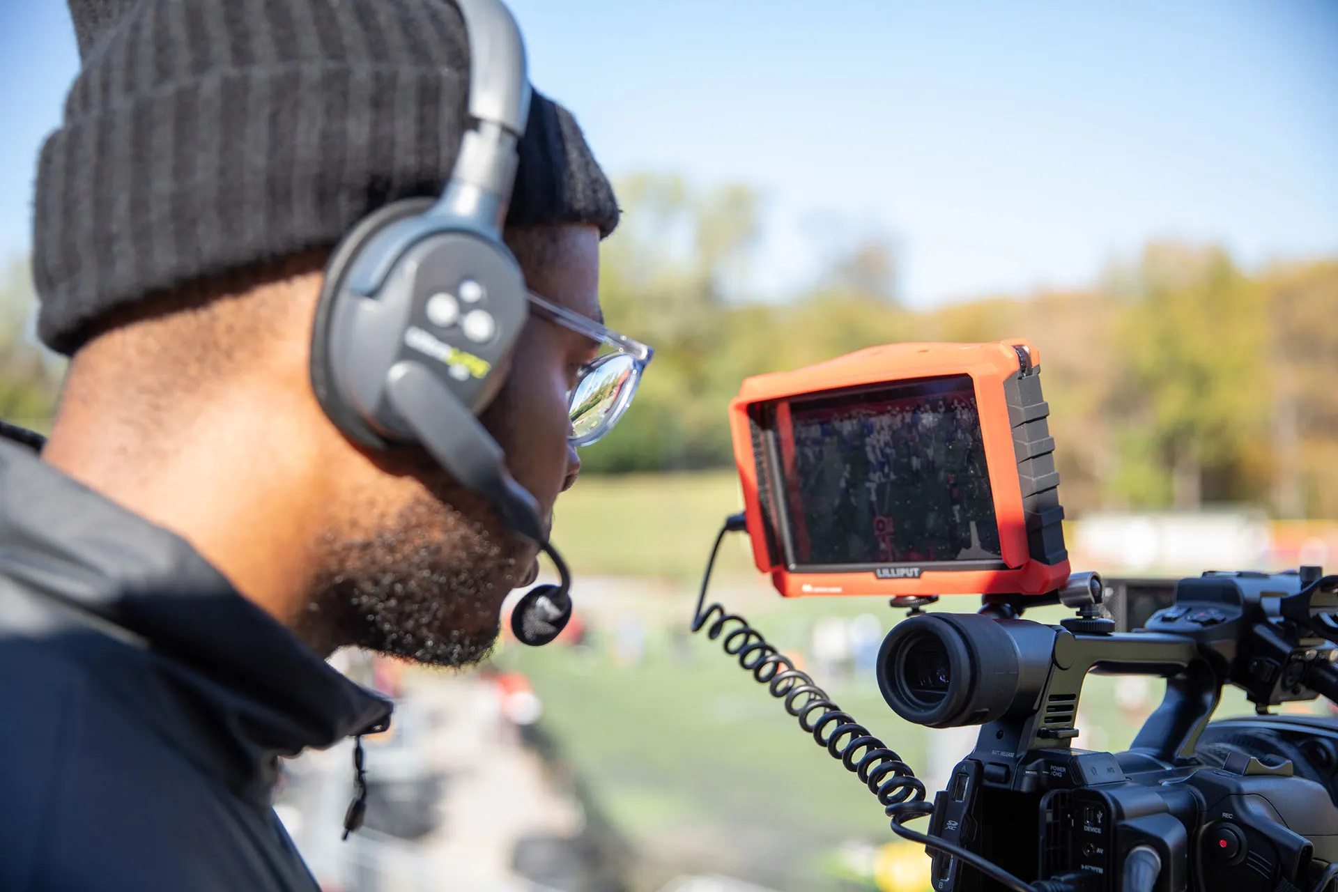 A broadcast camera operator tracking play from an elevated platform.