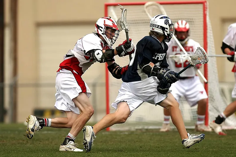 A men's lacrosse attacker driving toward the crease.
